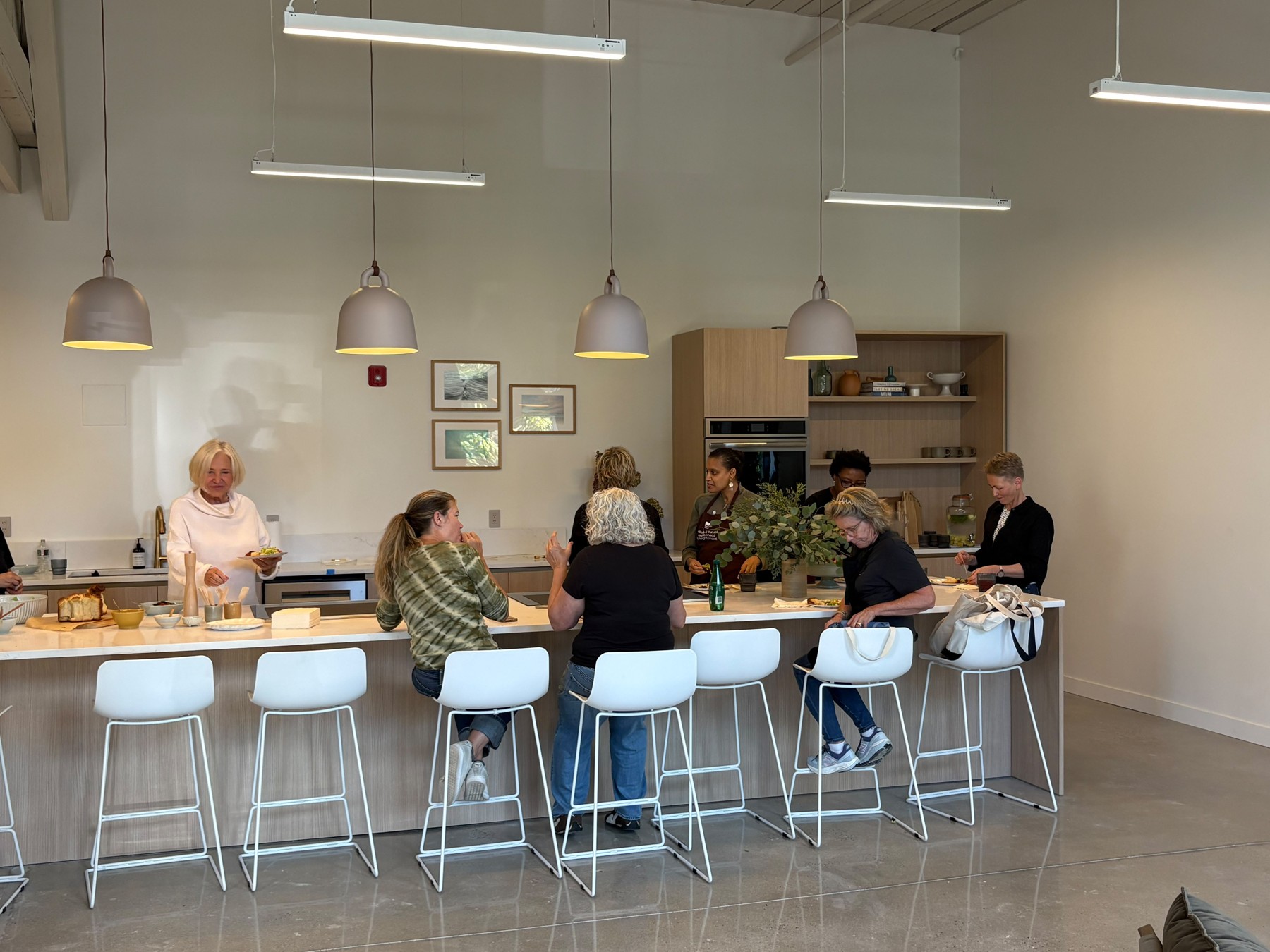 People gathered around the kitchen island at WOVEN